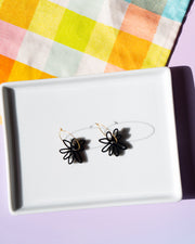 black flower gold hoop earrings on white tray