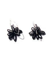 black flower silver hoop earrings over white 