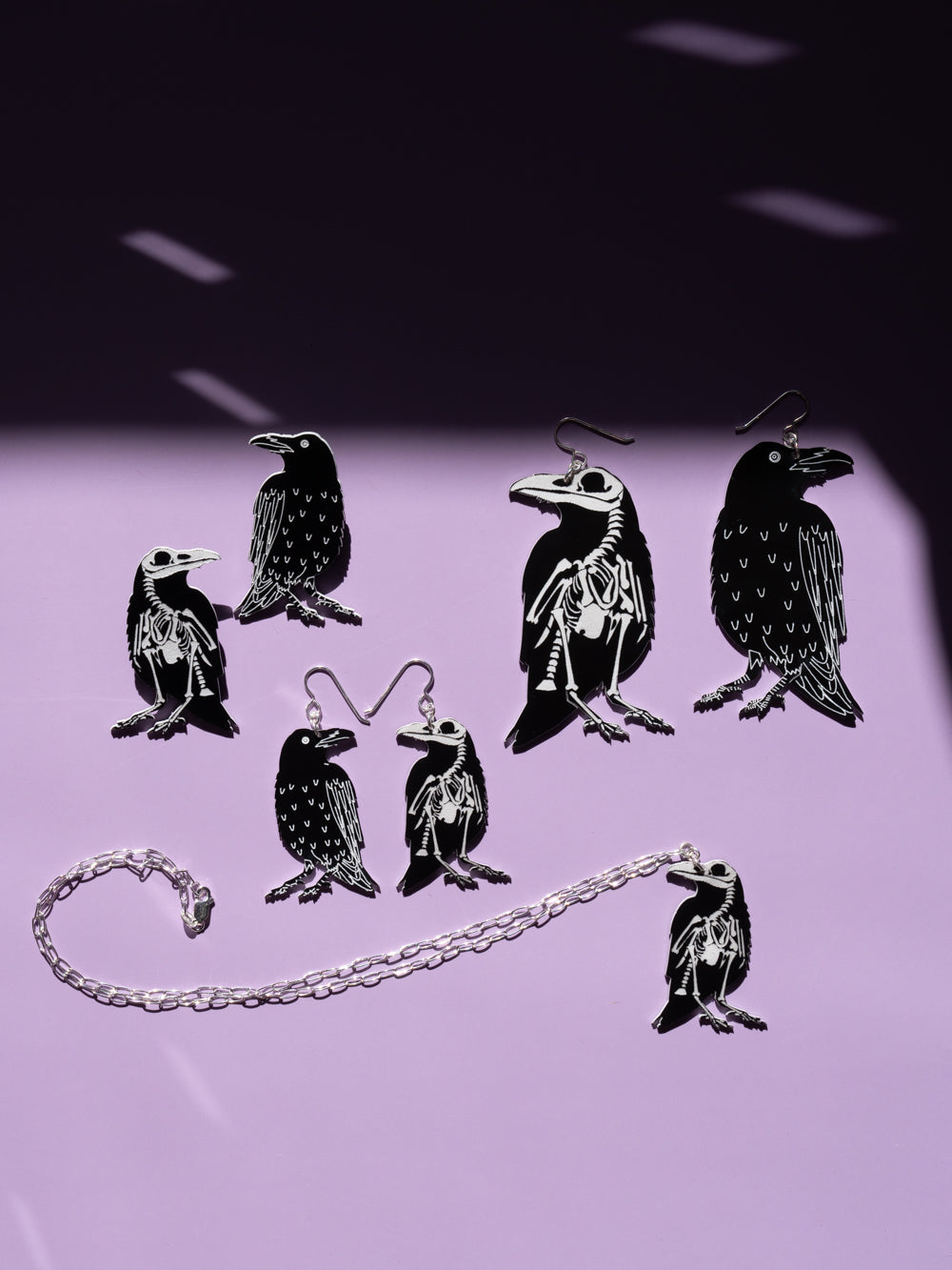 Raven jewelry crow jewelry over purple background