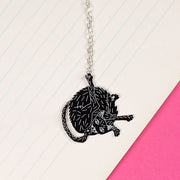 black cat necklace styled on notebook paper