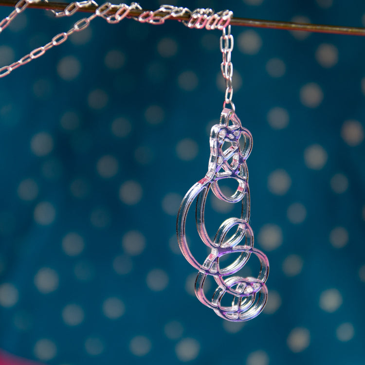 Iridescent pendant necklace over blue background