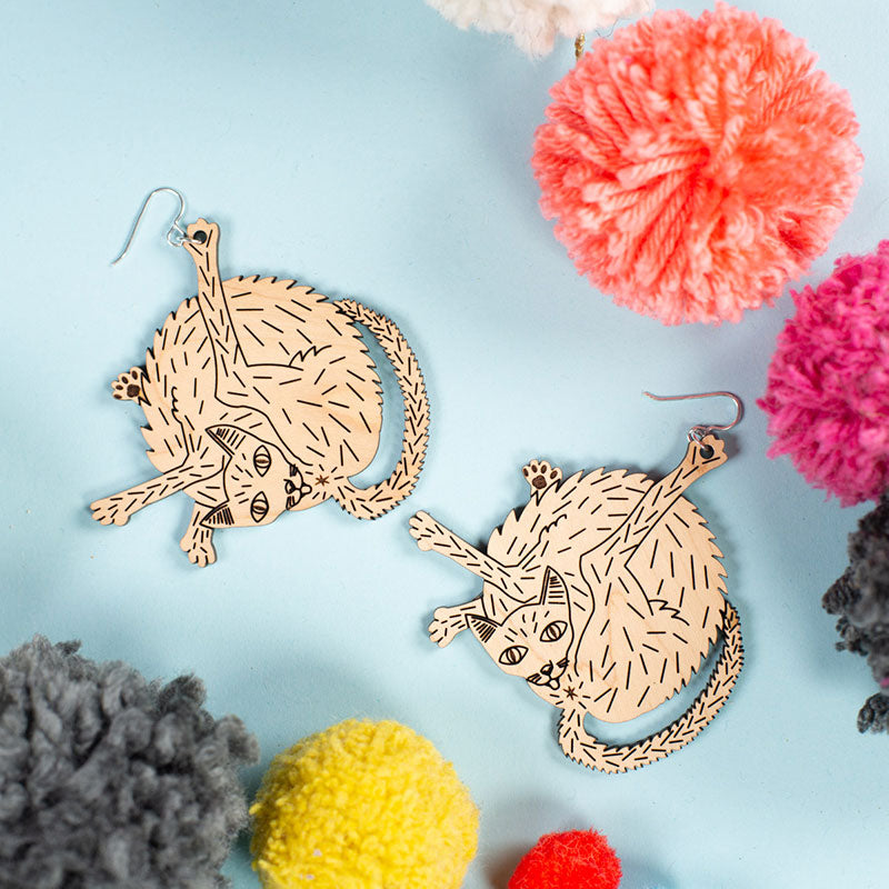 large wood cat earrings styled with pom poms