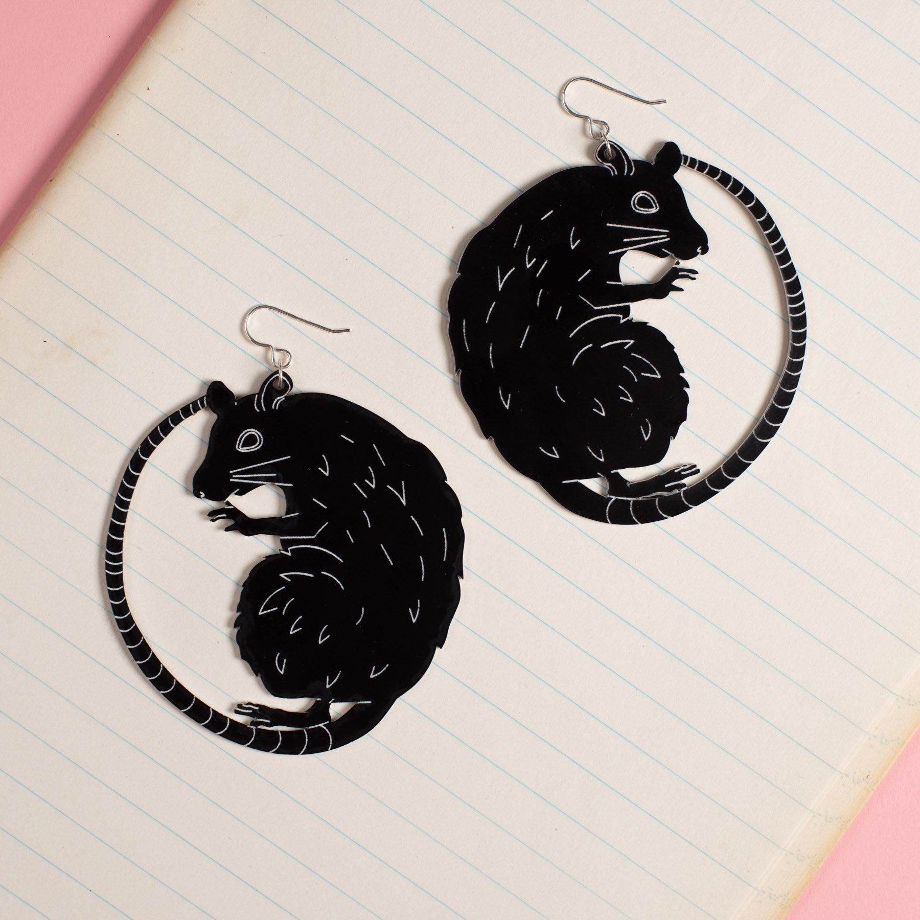 large black rat earrings atop a notebook