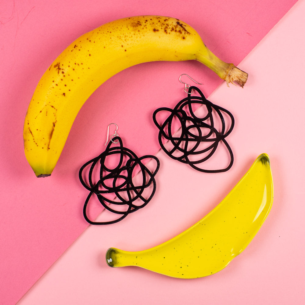 Big scribble earrings with bananas over pink backdrop