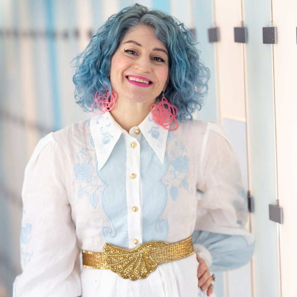 Kaelen Van Cura shown with blue hair and pink earrings