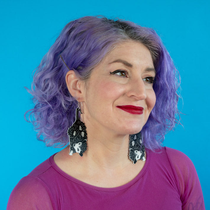 Large baby possum earrings shown on model