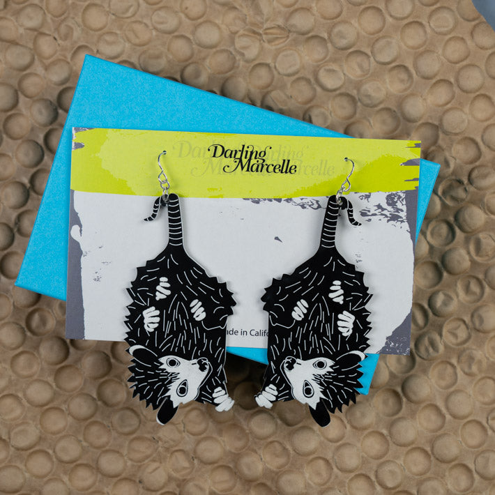 Baby possum earrings shown in package