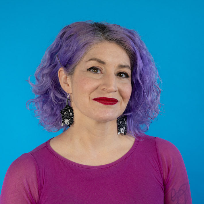 Small baby possum earrings shown on model