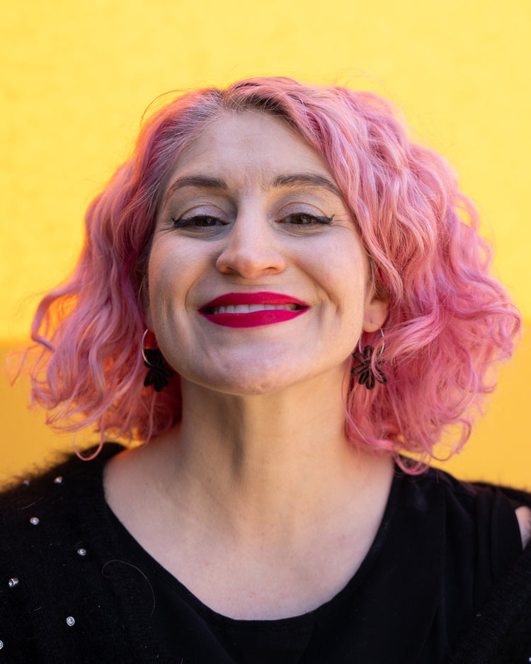 Model wearing black flower hoop earrings 