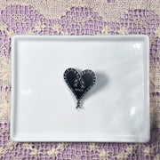 Heart of Snakes Pin reading "Amor" on a white tray
