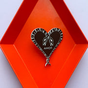 Heart of Snakes Pin reading "Amor" in orange geometric tray