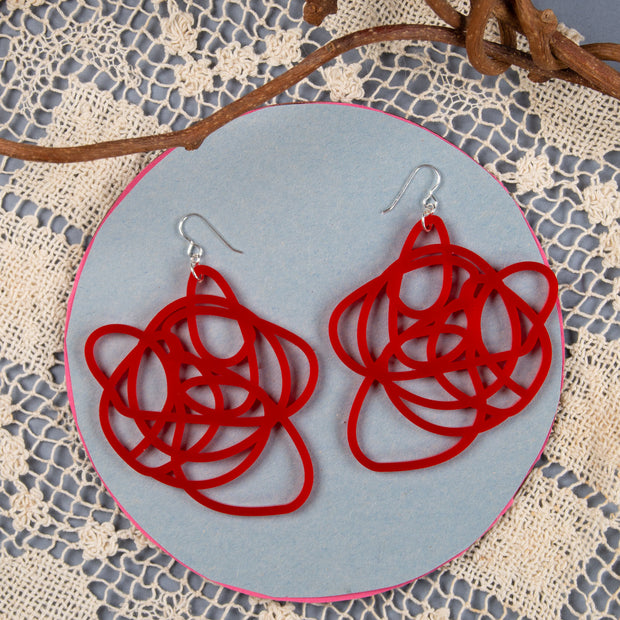lightweight red graffiti earrings shown on background with lace and branches