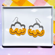 orange and silver cloud earrings on white tray
