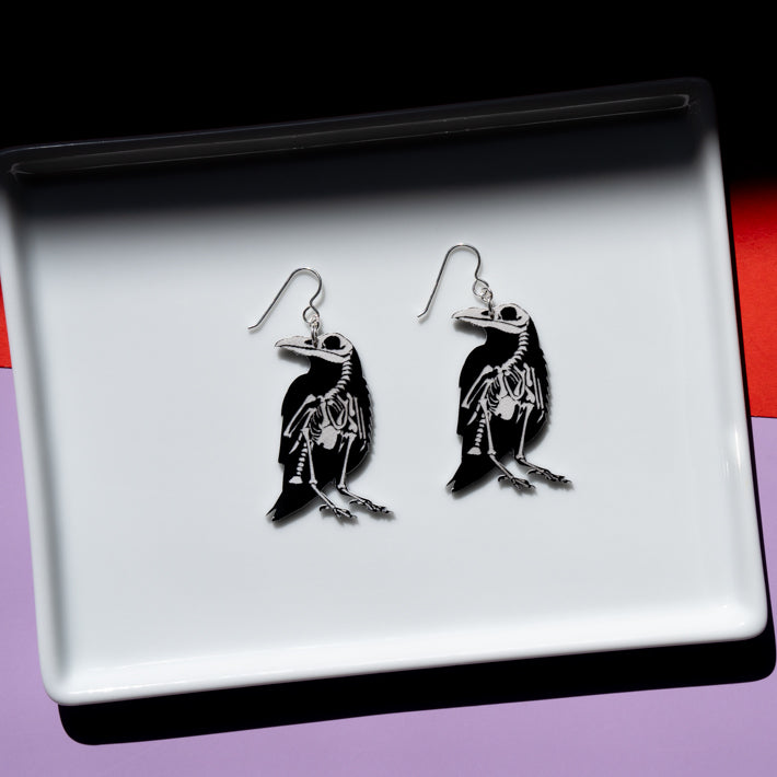 Small raven skeleton earrings, skeleton side shown