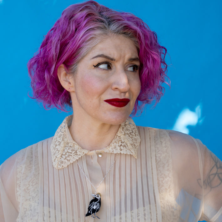 Raven skeleton necklace shown on model