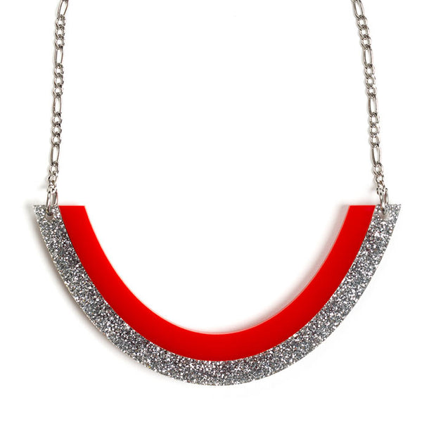 Red and silver necklace over white