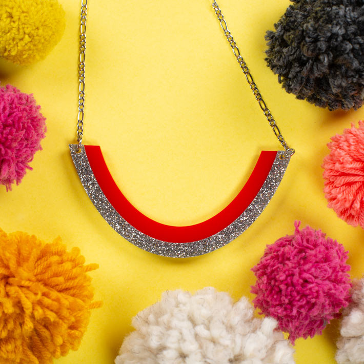 Red and silver smile necklace over colorful background
