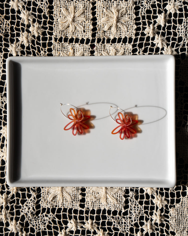 red orange flower hoop earrings  on white tray