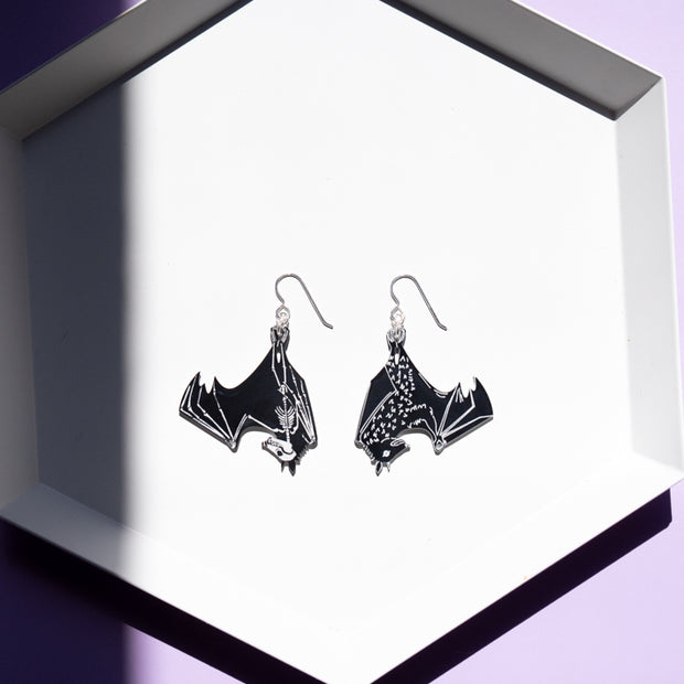 small bat skeleton earrings on white tray