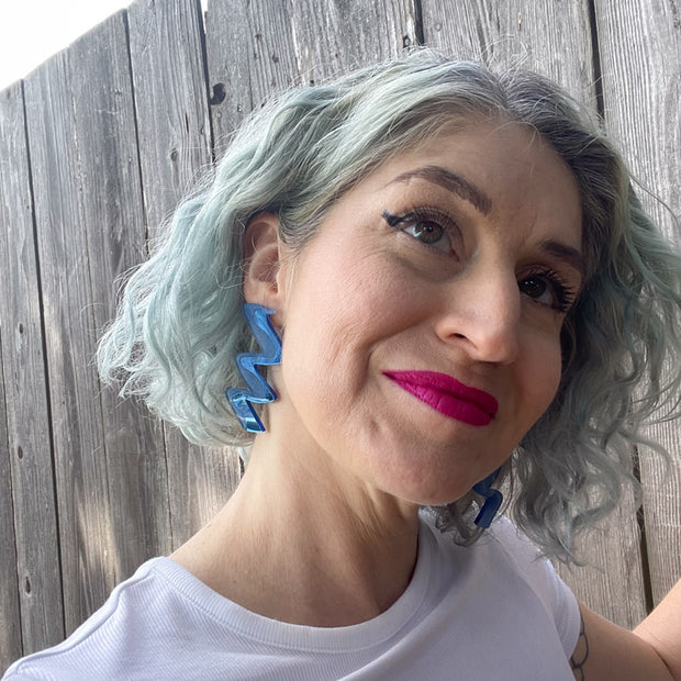 Model wearing blue acrylic earrings