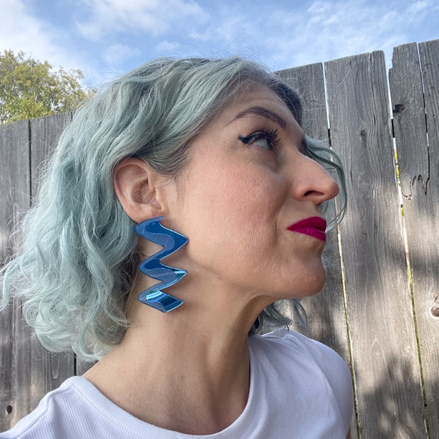Profile view of model wearing blue earrings