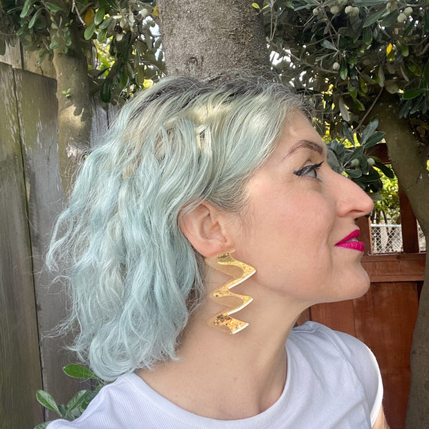 Profile of model wearing zigzag gold acrylic earrings