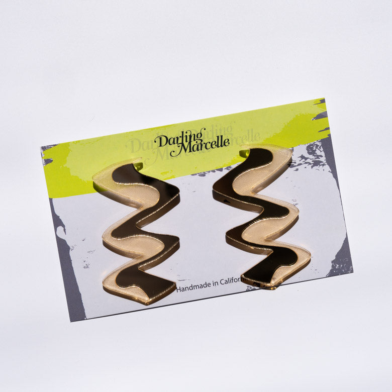 Zigzag gold acrylic earrings shown on card