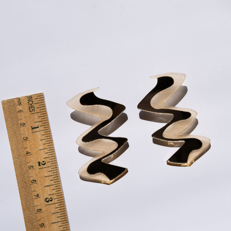 Zigzag gold acrylic earrings shown with ruler