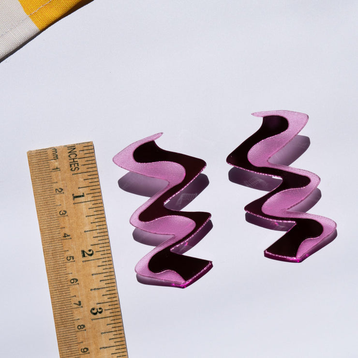 Zigzag pink acrylic earrings styled with ruler