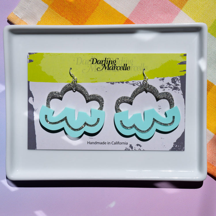 Aqua cloud earrings on earring card atop white tray