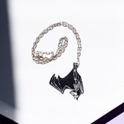 black bat skeleton necklace on a white tray