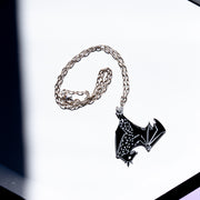 black bat necklace on white tray