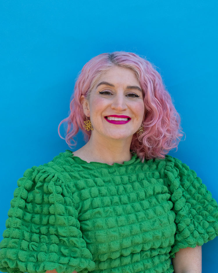 Model wearing gold flower hoops