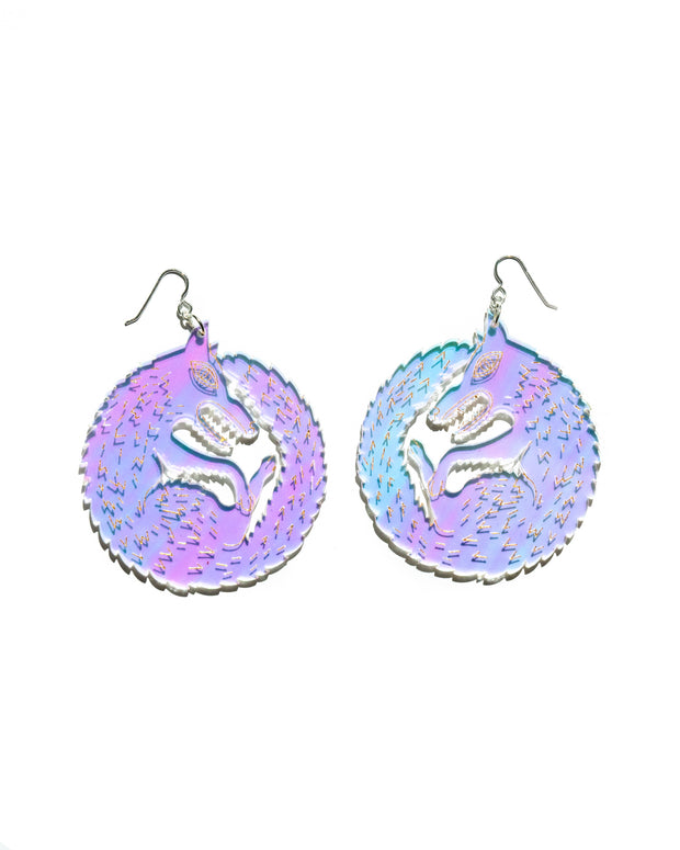Large wolf earrings over white background