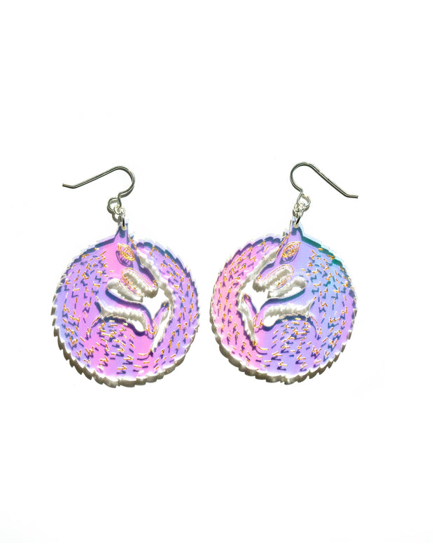Small iridescent wolf earrings over white background