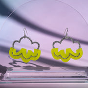 green cloud earrings on clear acrylic stand in front of purple background