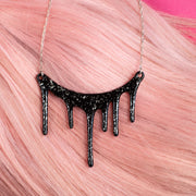 black and silver drip necklace over pink hair