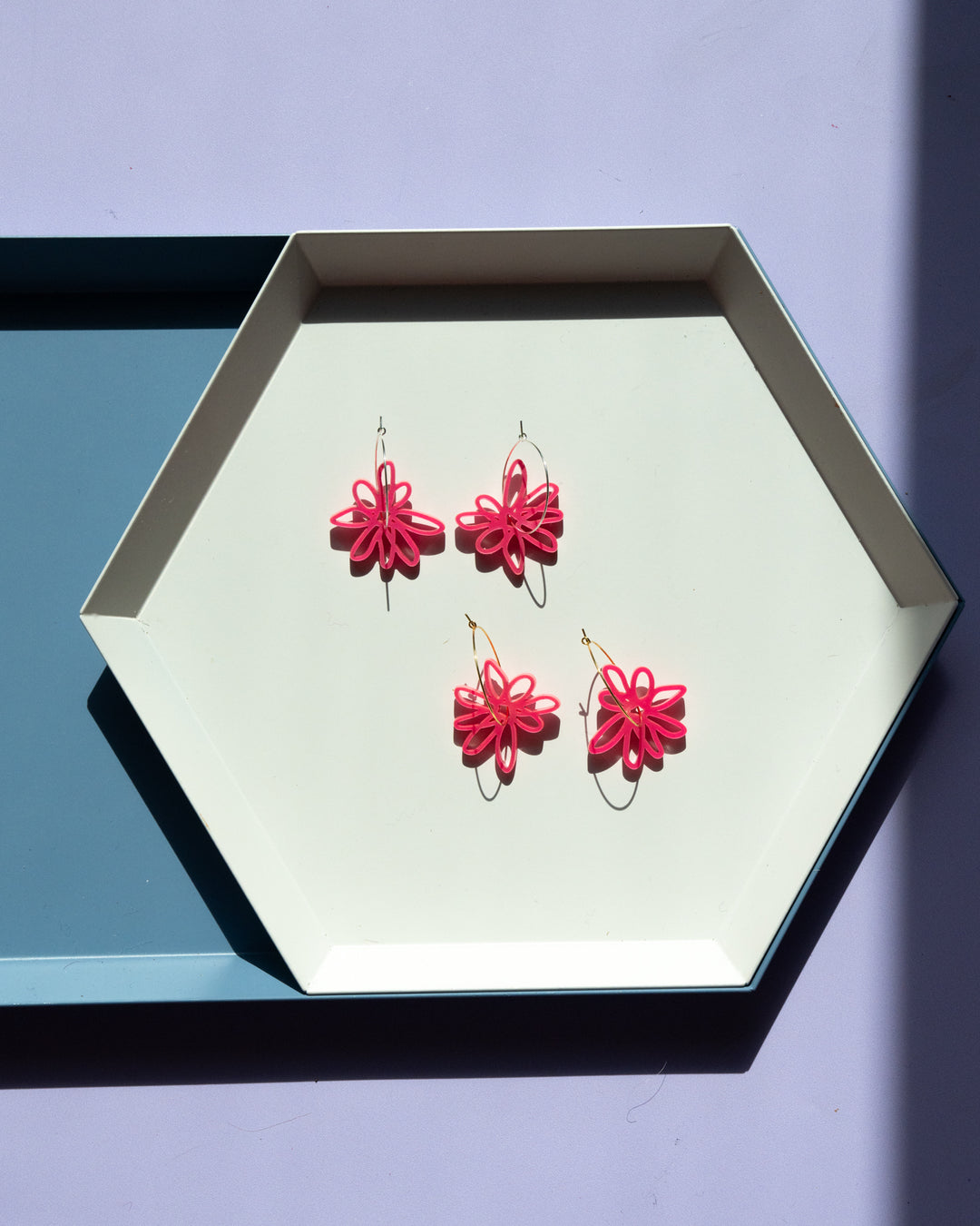 pink flower hoop earrings on geometric tray