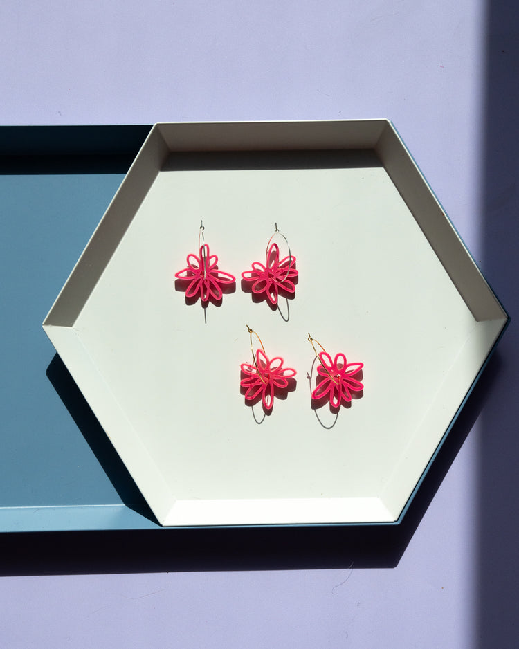 pink flower hoop earrings on geometric tray