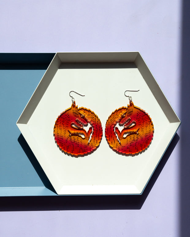 Large red orange wolf earrings in white tray
