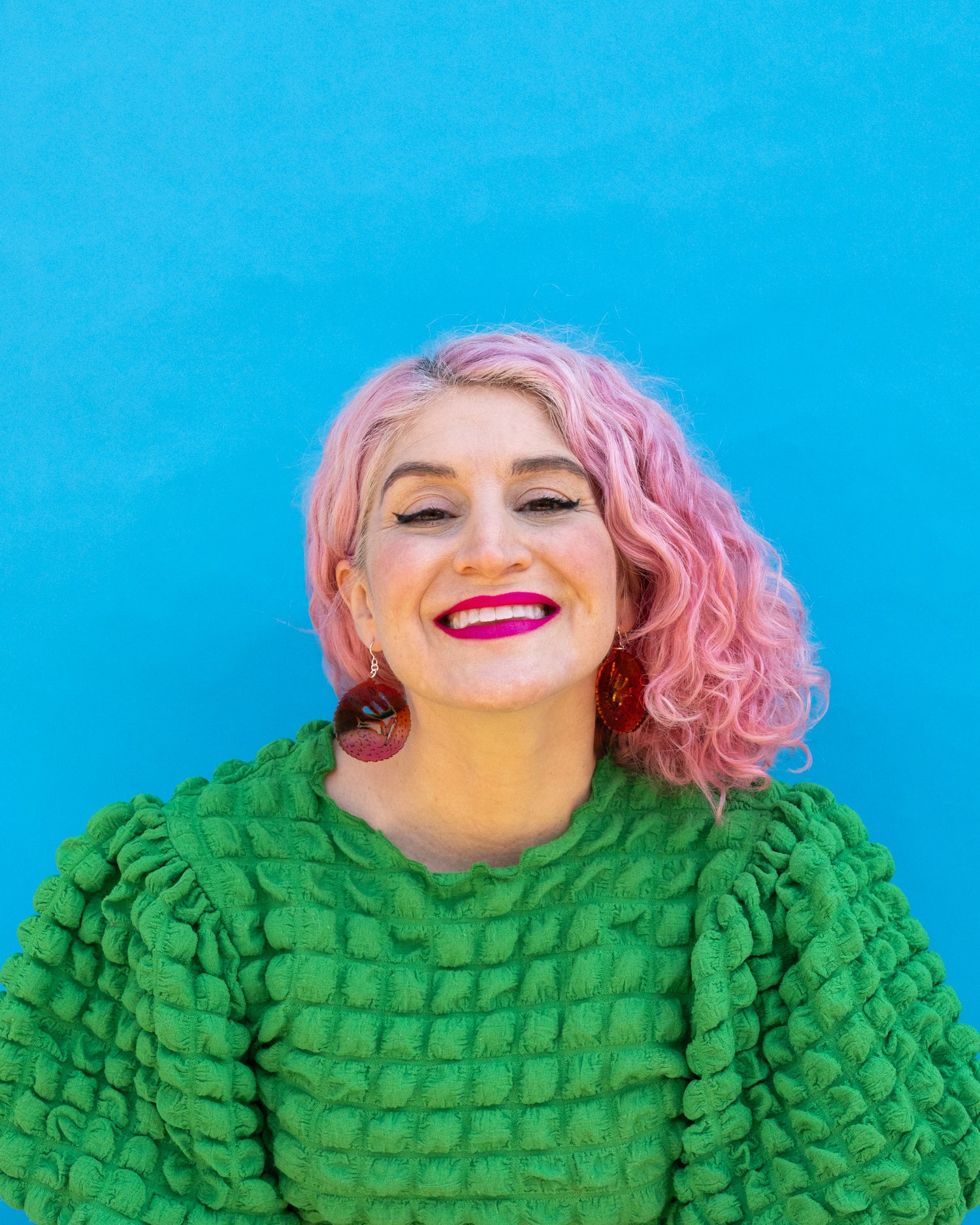 Small red orange wolf earrings on model