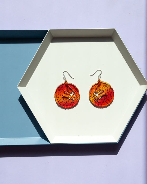 small red orange wold earrings in geometric tray