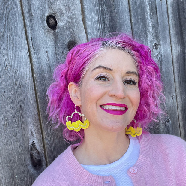 yellow cloud earrings shown on white model with pink hair against a wooden fence
