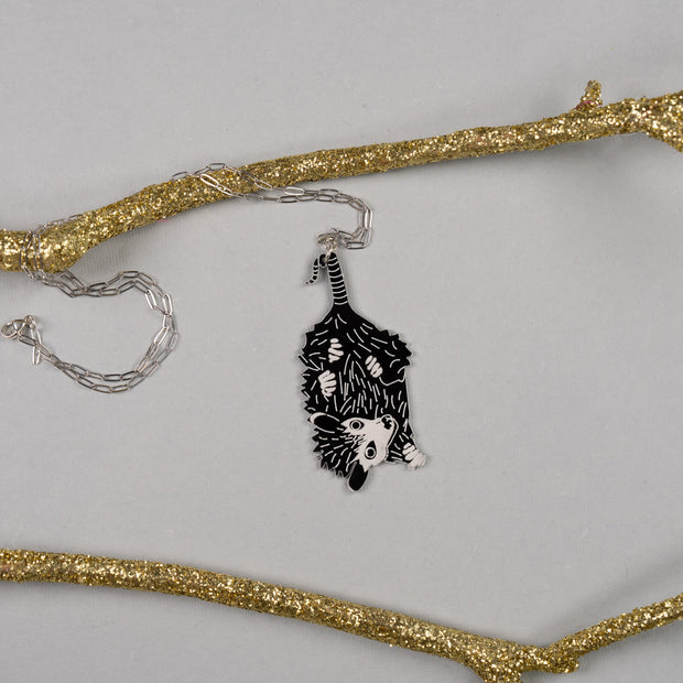 Baby possum necklace shown on gray background with gold branches
