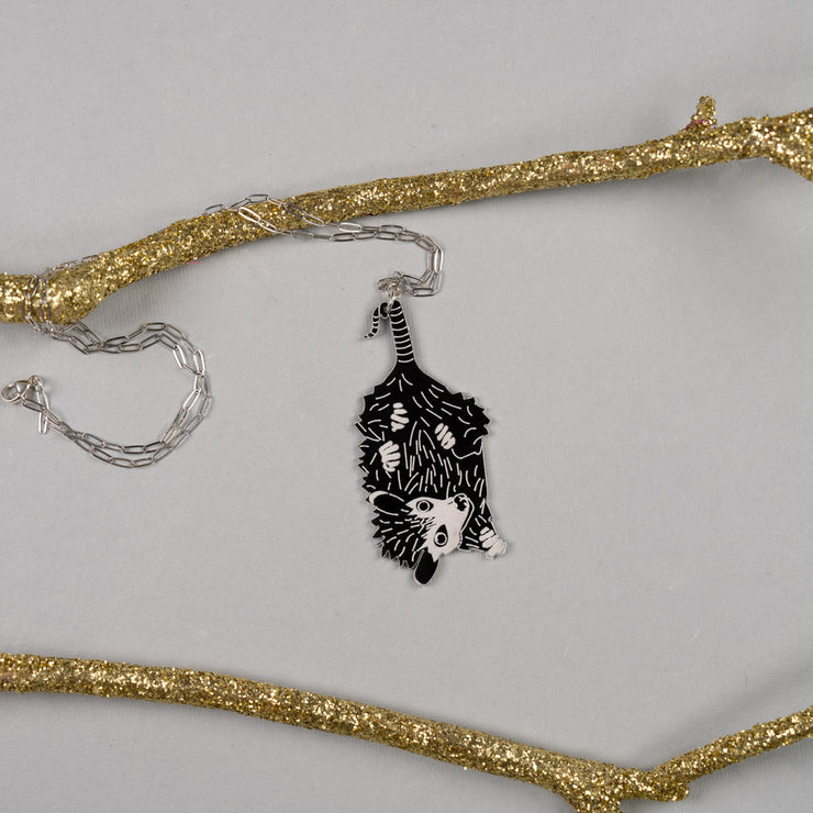 Baby possum necklace shown on gray background with gold branches