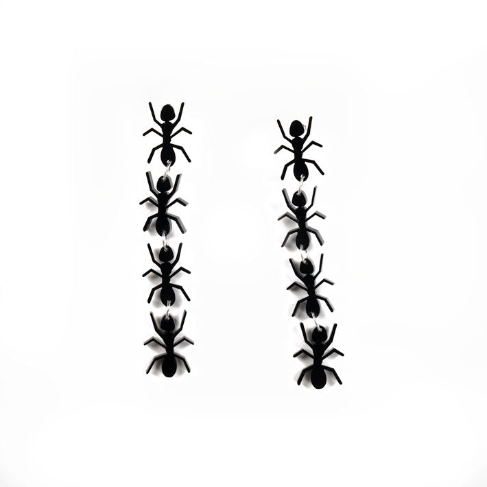 black ant earrings over white background