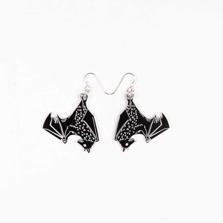 black bat earrings over white background