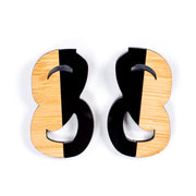 Black and wood statement stud earrings on white background