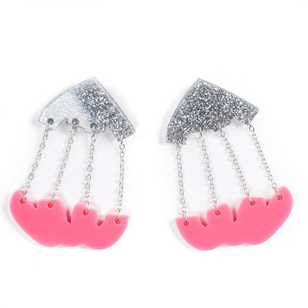 Silver and pink dangle earrings over white