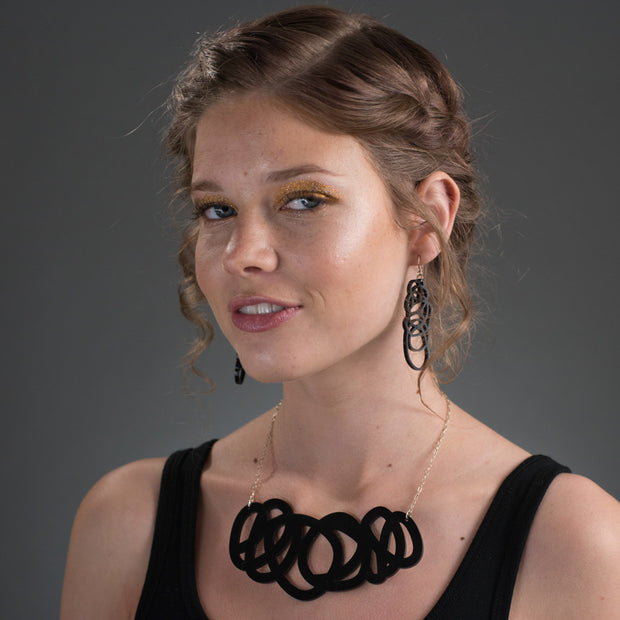 Chunky black statement necklace on model